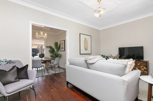 Living area with floorboards and light grey furnishings.