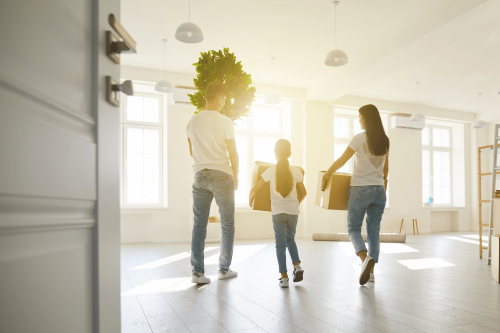Family walking into a home with boxes.